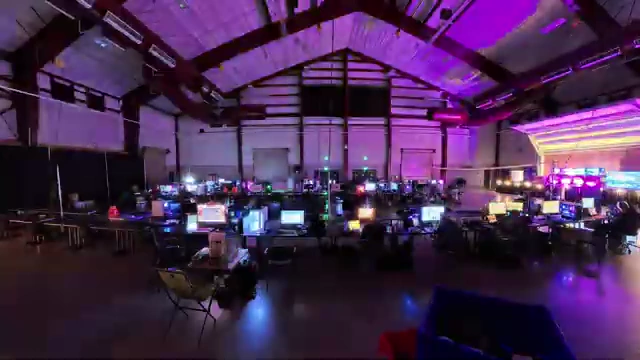 A wide shot of the LANFest venue completely filled with gamers, their computers, and colorful lighting during the event.