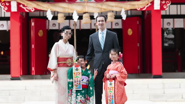 The speaker with his family in traditional Japanese attire, showing his personal connection to living in Japan.