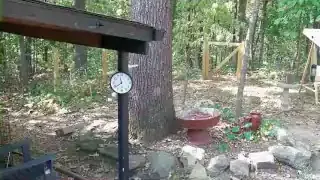 A microphone setup recording outdoors near a house, capturing ambient sounds.