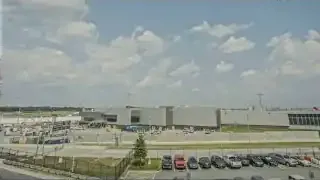 An aerial view of a large, busy airport terminal and its surrounding infrastructure.