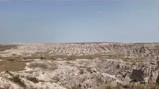 The vast, rugged landscape of Badlands National Park, characterized by eroded buttes and canyons.