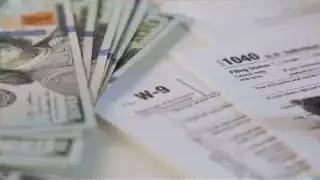 Tax forms and scattered dollar bills, symbolizing the financial impact of tax incentives