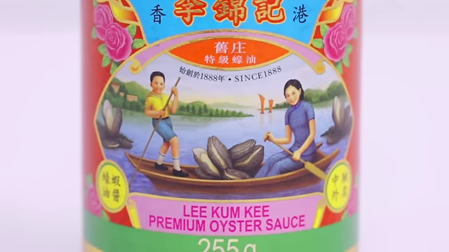 A close-up of the Lee Kum Kee Premium Oyster Sauce label, showing a lady and boy in a boat with oysters.