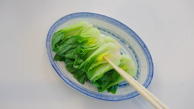 Blanched baby bok choy arranged on a plate, ready to be served with oyster sauce for a simple, flavorful dish.
