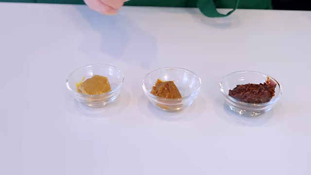 Three bowls of miso, demonstrating the color and texture differences between white, yellow, and red miso varieties.