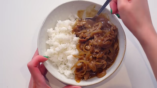 A bowl of Beef Kare with thinly sliced beef and caramelized onions smothered in a velvety thick curry sauce, served over rice.