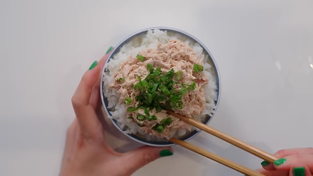 Tuna mixed with Kewpie mayonnaise and served over a bowl of rice, topped with chopped green onions.