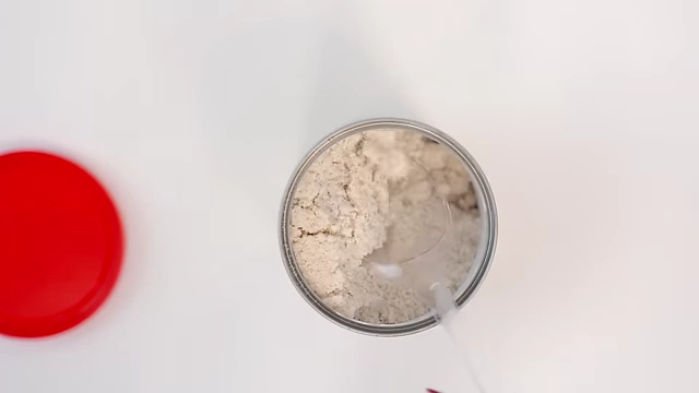 A spoon scooping chicken bouillon powder from the can.