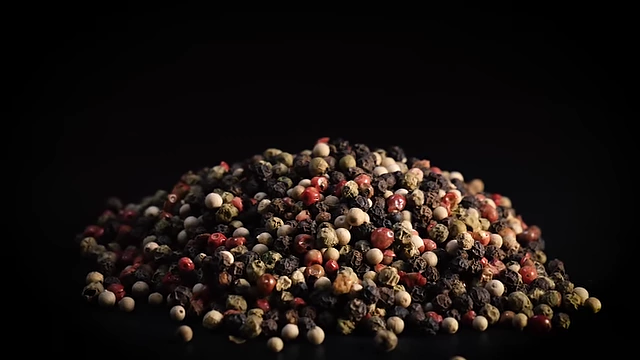 A mix of whole peppercorns (black, white, green, red), showing the raw ingredient varieties.