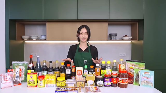 A wide array of Asian condiments laid out on a table with the speaker.