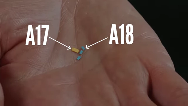 A close-up of tiny A17 (yellow) and A18 (blue) paper pieces held in a hand.