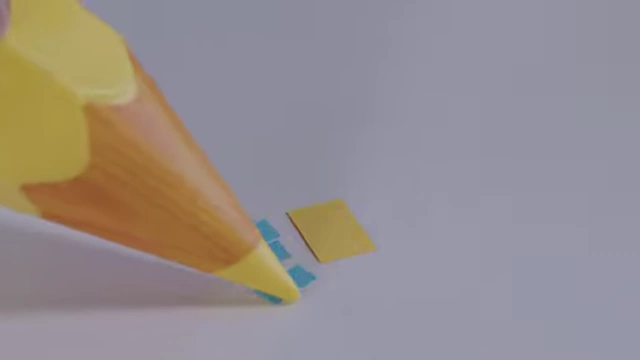 A close-up of a pencil arranging tiny A18 paper pieces next to an A17 piece, demonstrating their fit.