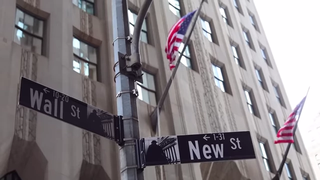 Street sign indicating "Wall St" and "New St" in a financial district