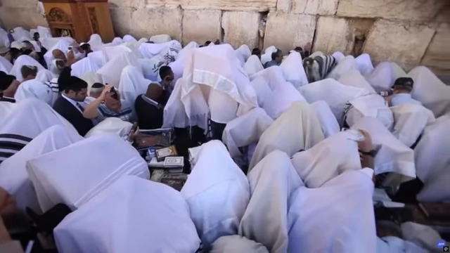 Jewish men praying at the Western Wall in Jerusalem, representing the religious nature of the Jewish people
