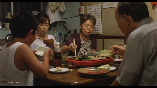 Film still showing a family enjoying a meal together from the movie "I Wish".