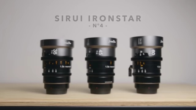A set of three Sirui Iron Star anamorphic lenses lined up on a wooden surface