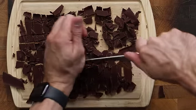 Chopping the frozen chocolate slab into bite-sized chunks for mint chocolate chip ice cream.