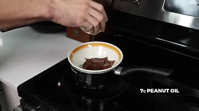 Adding 7g of peanut oil to melted chocolate to achieve desired texture.