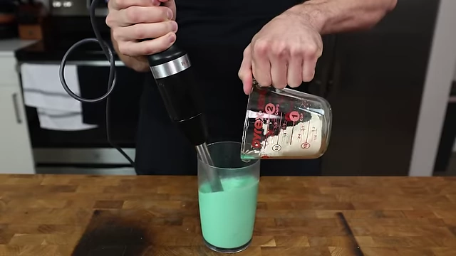 Slowly incorporating dry ingredients into wet ingredients using an immersion blender.