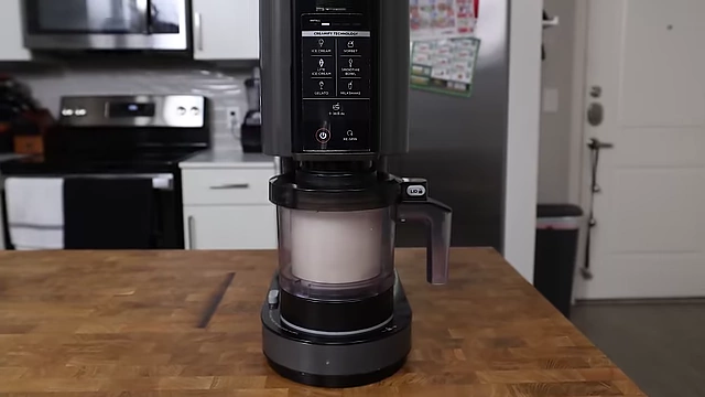 Selecting the 'Light Ice Cream' function on the Ninja CREAMi for a soft-serve consistency.