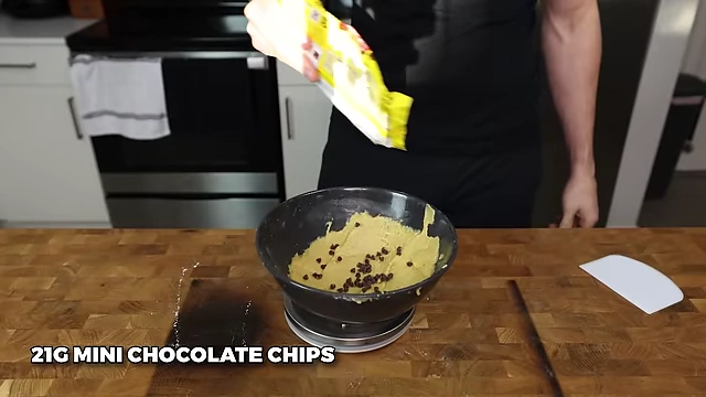 Adding 21g of mini chocolate chips to the cookie dough.