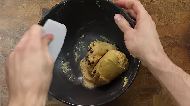 Mixing mini chocolate chips into the dense protein cookie dough.