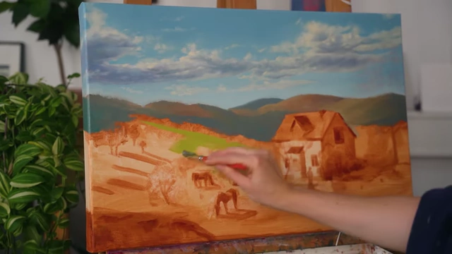 Adding the first layer of green to the rolling hills in the landscape painting.