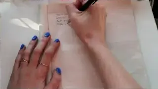 A hand writing a list of tasks in a notebook.