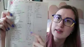 A person holding up a notebook page displaying a handwritten list of tasks with symbols indicating priority and estimated time.