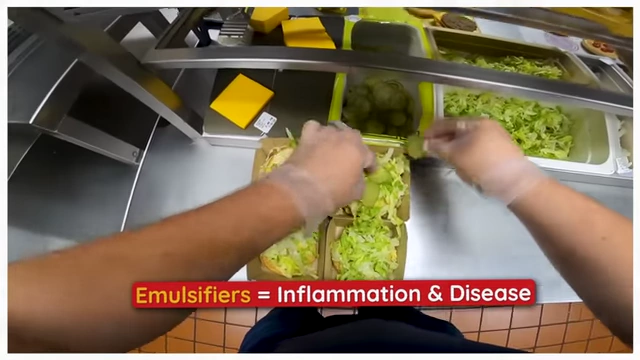 A POV shot from inside a McDonald's kitchen showing ingredients being added to Big Macs, with an overlay stating "Emulsifiers = Inflammation & Disease".