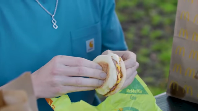 The presenter unwrapping an Egg McMuffin.