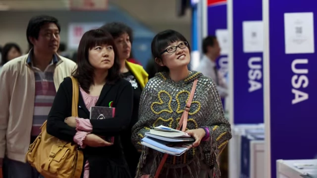 Chinese students at an education fair, showing interest in studying in the USA