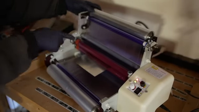 A customized laminator with added take-up spools, essential for correctly applying dry film photoresist to metal sheets by peeling off the soft protective layer.