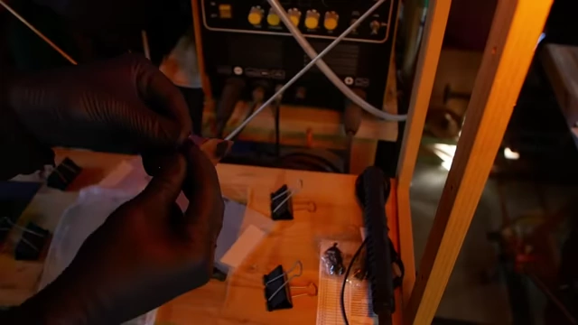 Hands carefully peeling off the hard plastic protective layer from the photoresist, preparing the panel for development.