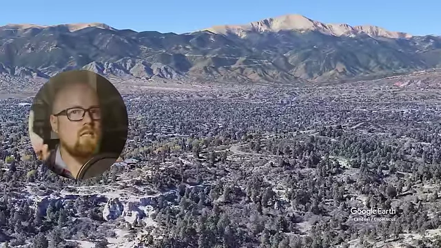 科罗拉多斯普林斯市中心区域全景，背景是雄伟的山脉