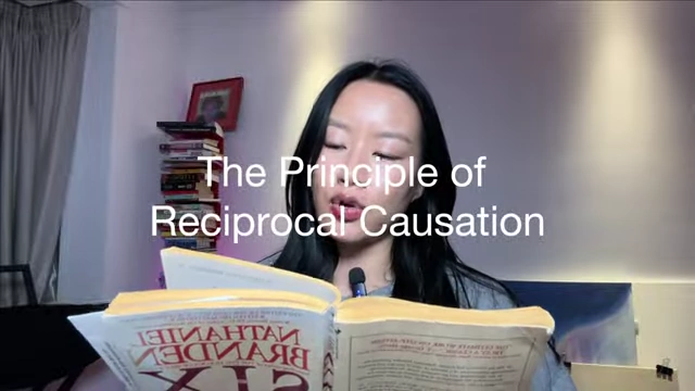 The Principle of Reciprocal Causation text overlay on a person holding the book