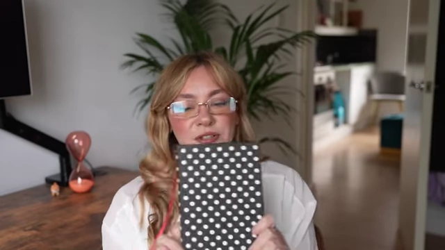 The speaker holds up her notebook, which contains notes for the 'Seven Levels Deep' exercise