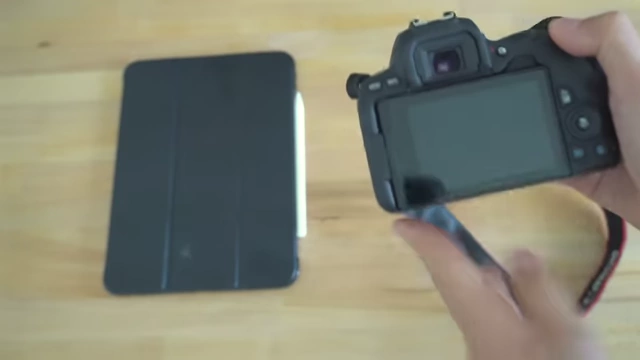 A DSLR camera and an iPad, representing heavy and unused tech for travel