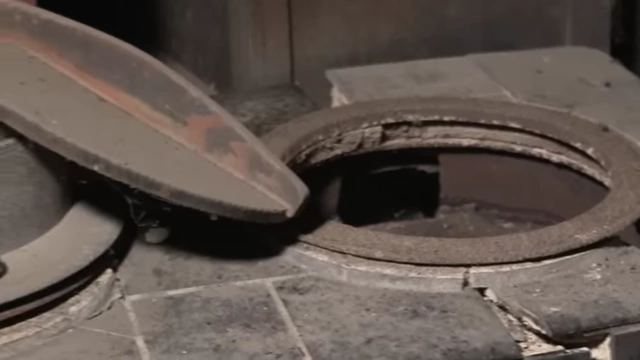 An old, rusty cooking stove in an abandoned Akiya, indicating outdated infrastructure.