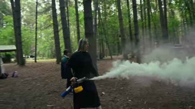 A crew member applying fog in the forest using an insect fogger.