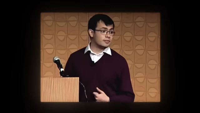 A younger Demis Hassabis presenting on AI in an early academic setting
