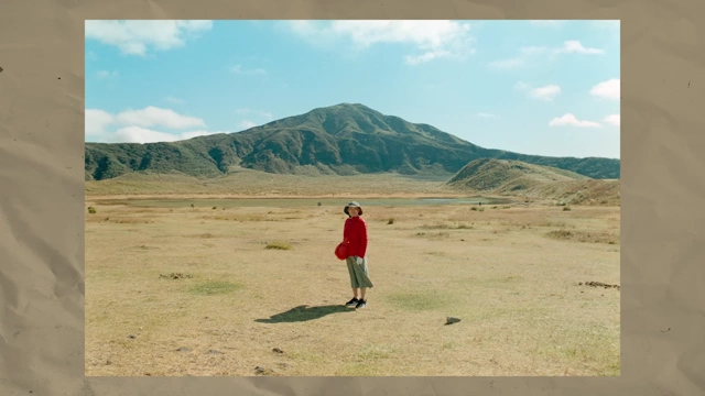 Teo Crawford's grandma walking in a vast, dry field under a wide sky in Aso