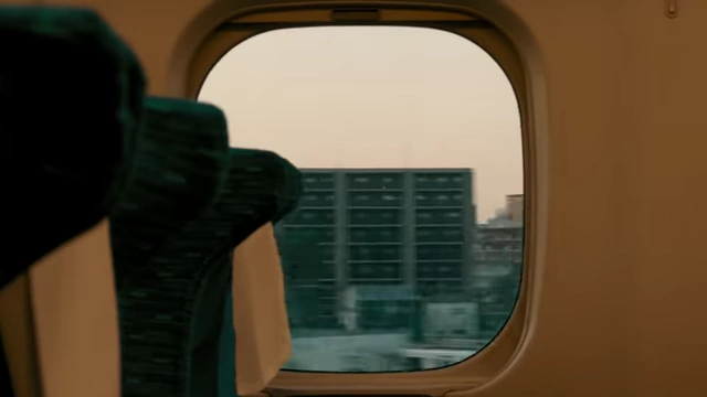 Teo Crawford and his grandma traveling by Shinkansen, with views of the Japanese countryside passing by outside the window.