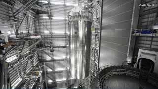 SpaceX's Starship lifted vertically inside the Megabay by a crane.