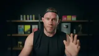 Speaker gesturing, possibly referring to a before/after photo of his physique.
