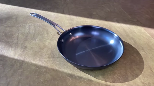 Anolon pan showcasing its elegant polished finish and curved handle.