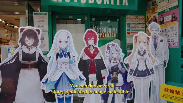 A vibrant display of life-size anime character standees outside a Kotobukiya store in Nipponbashi, Den Den Town, showcasing the otaku culture.