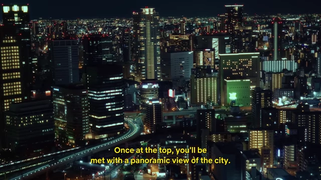 A stunning panoramic night view of the illuminated Osaka city skyline from the Umeda Sky Building observatory.