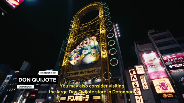 The exterior of the large Don Quijote store in Dotonbori, featuring its distinctive yellow Ferris wheel adorned with characters.