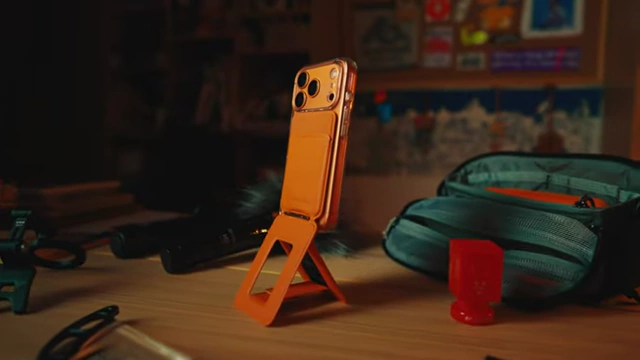 A smartphone attached to a MOFT Tripod Wallet, standing upright